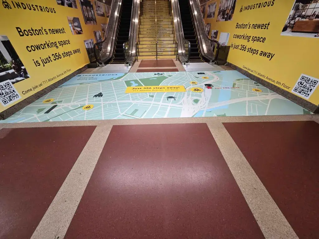 Industrious coworking escalator and floor wayfinding graphics at South Station, Boston