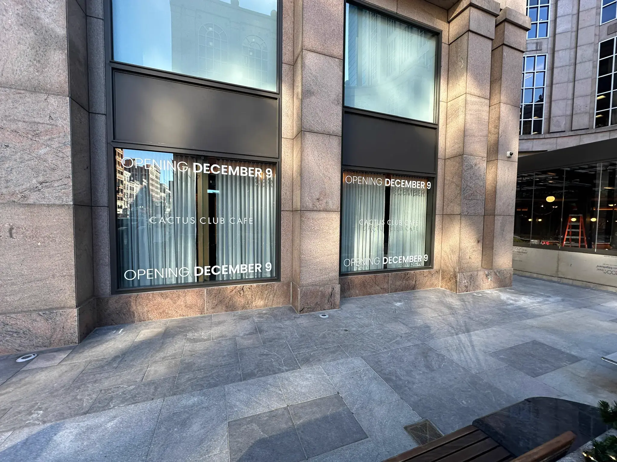 Opening December 9 Cactus Club Cafe window vinyl with a step ladder visible inside