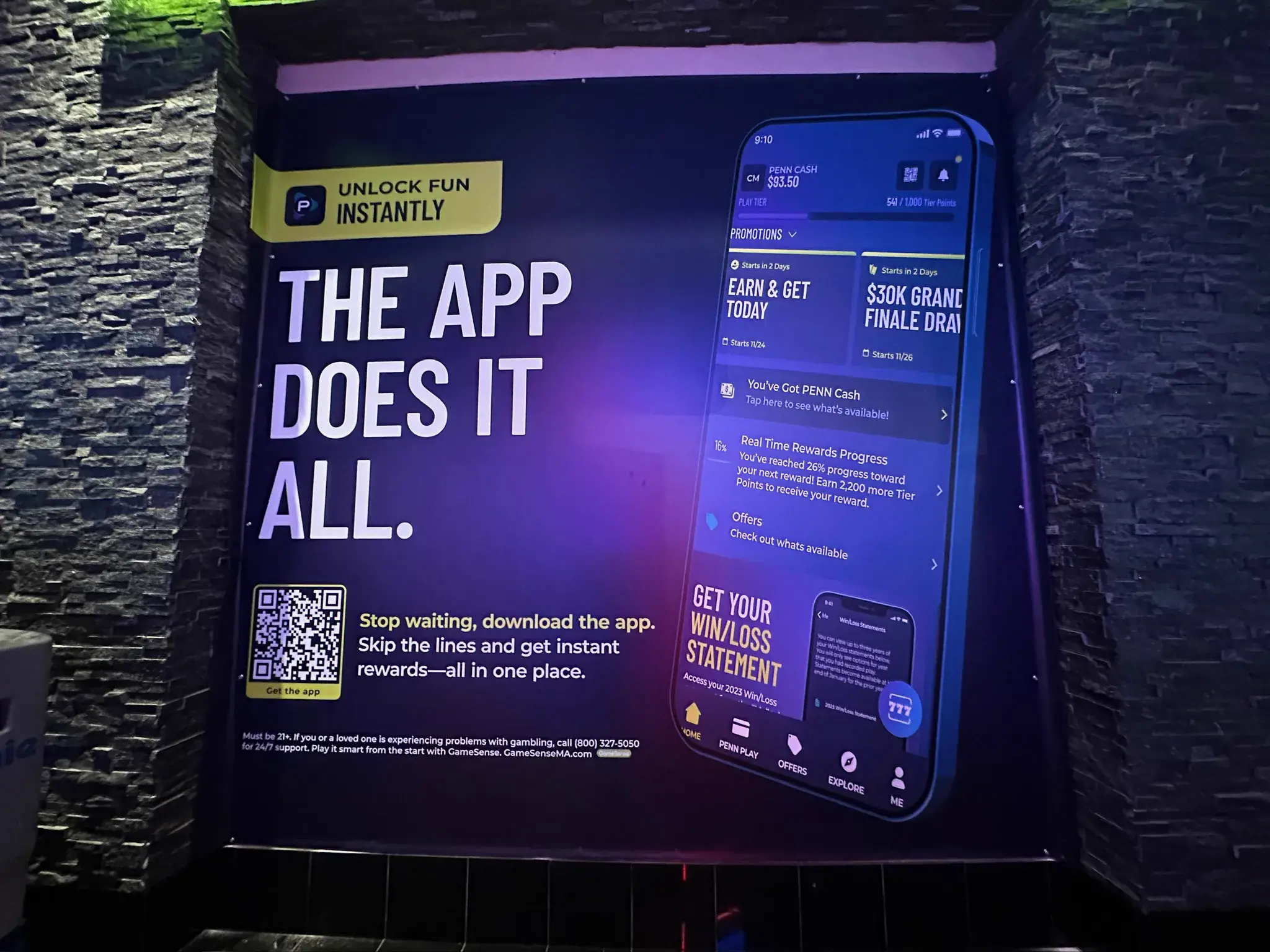 PENN Play app promotion graphic mounted on a stone interior wall