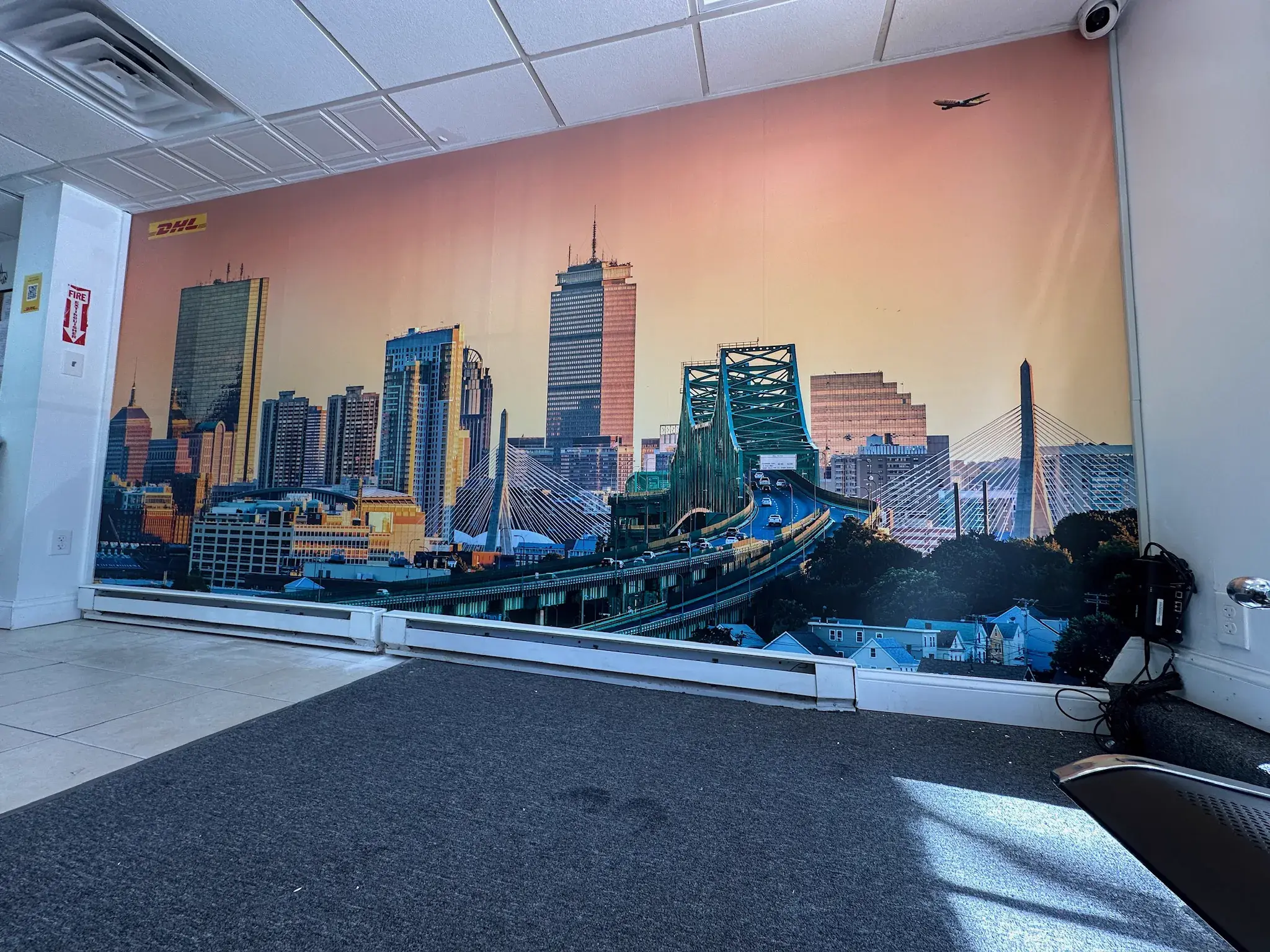 Printed Boston skyline mural with a DHL logo covering an office wall