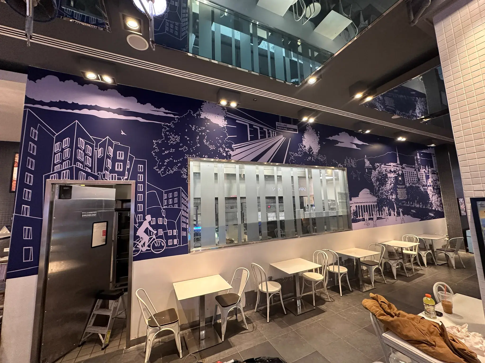 Navy line art mural mid-install with a step ladder and drop sheets