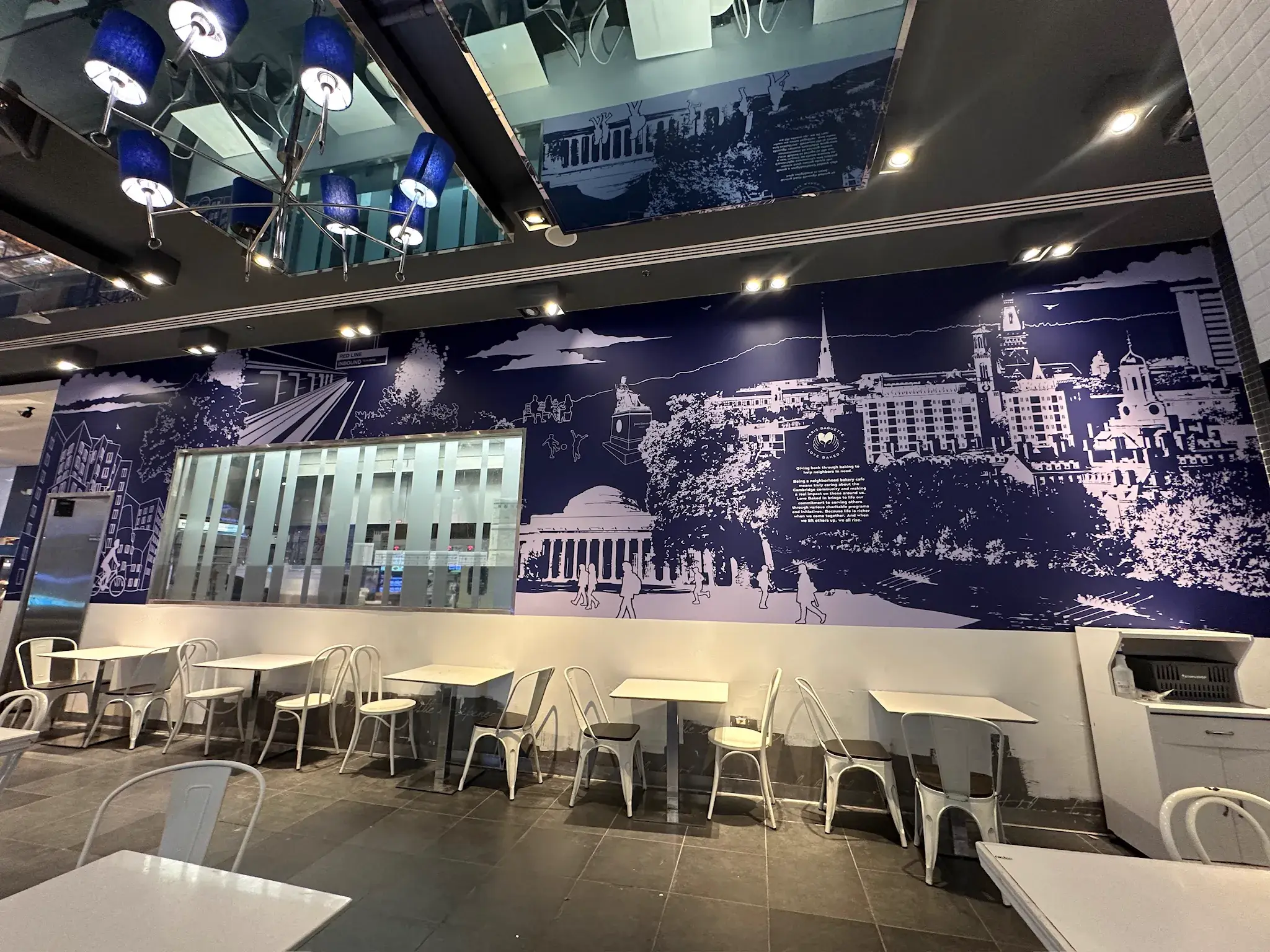 Navy line-art mural of the Cambridge skyline with a Paris Baguette logo