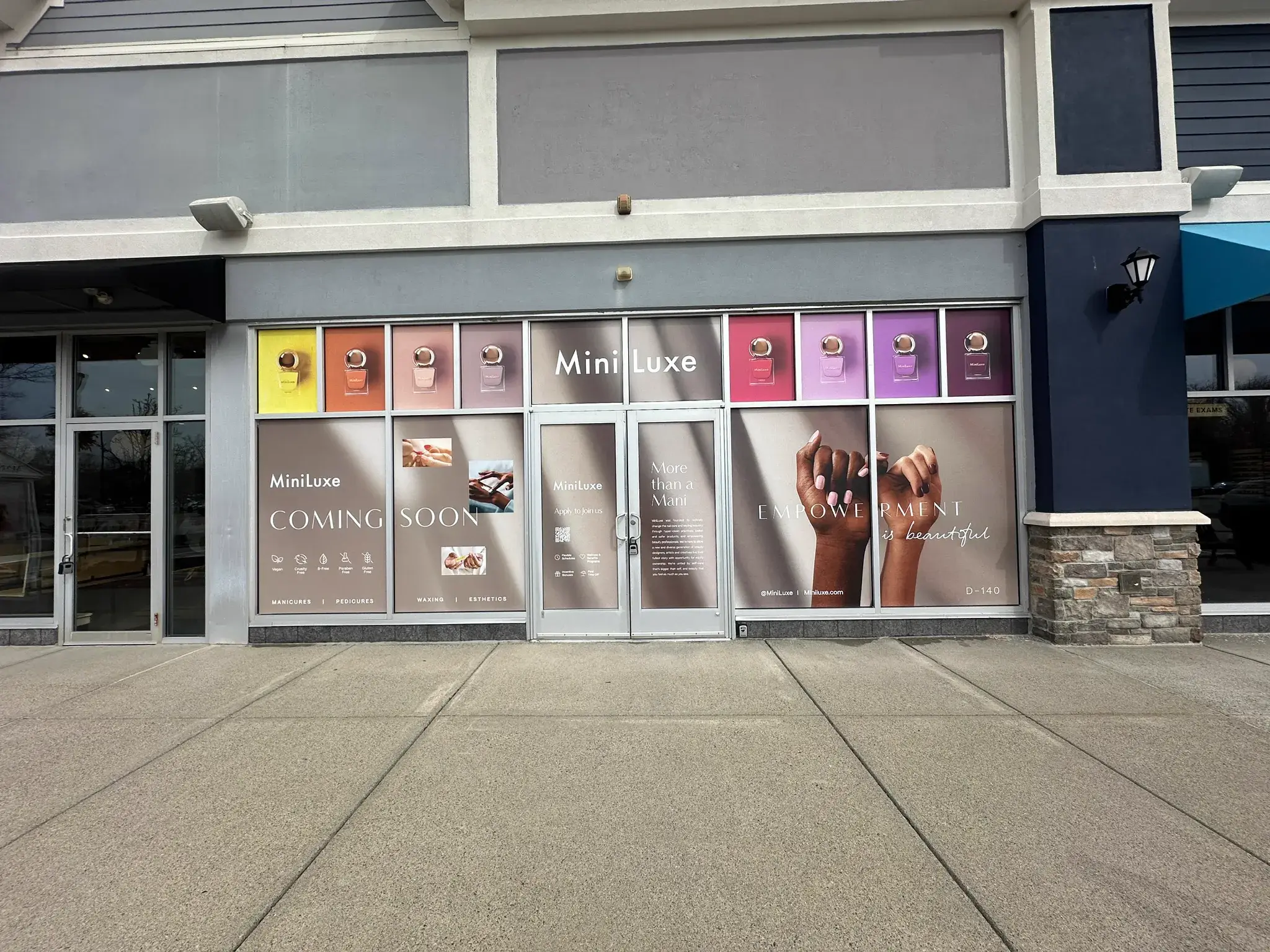 MiniLuxe storefront glass wrapped with nail polish panels and coming soon copy