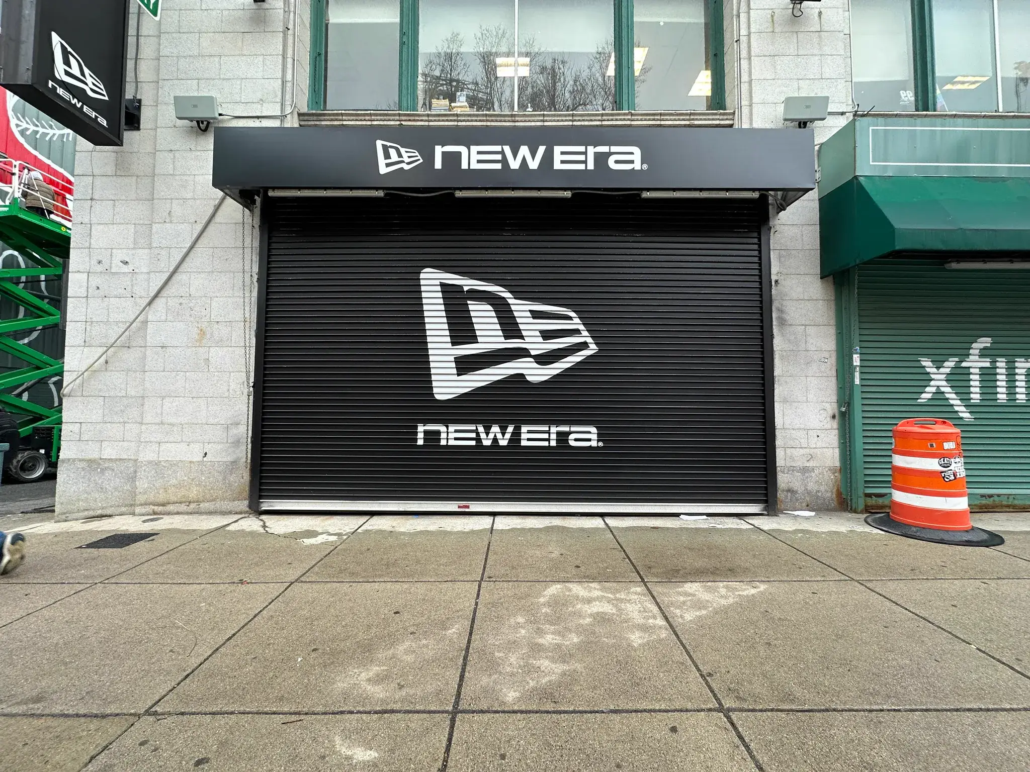 New Era flag logo printed across a black roll-down security shutter