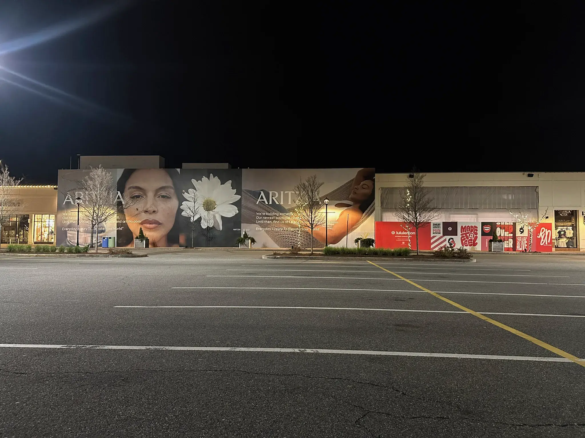 Night view of adjacent Aritzia and lululemon hoarding runs