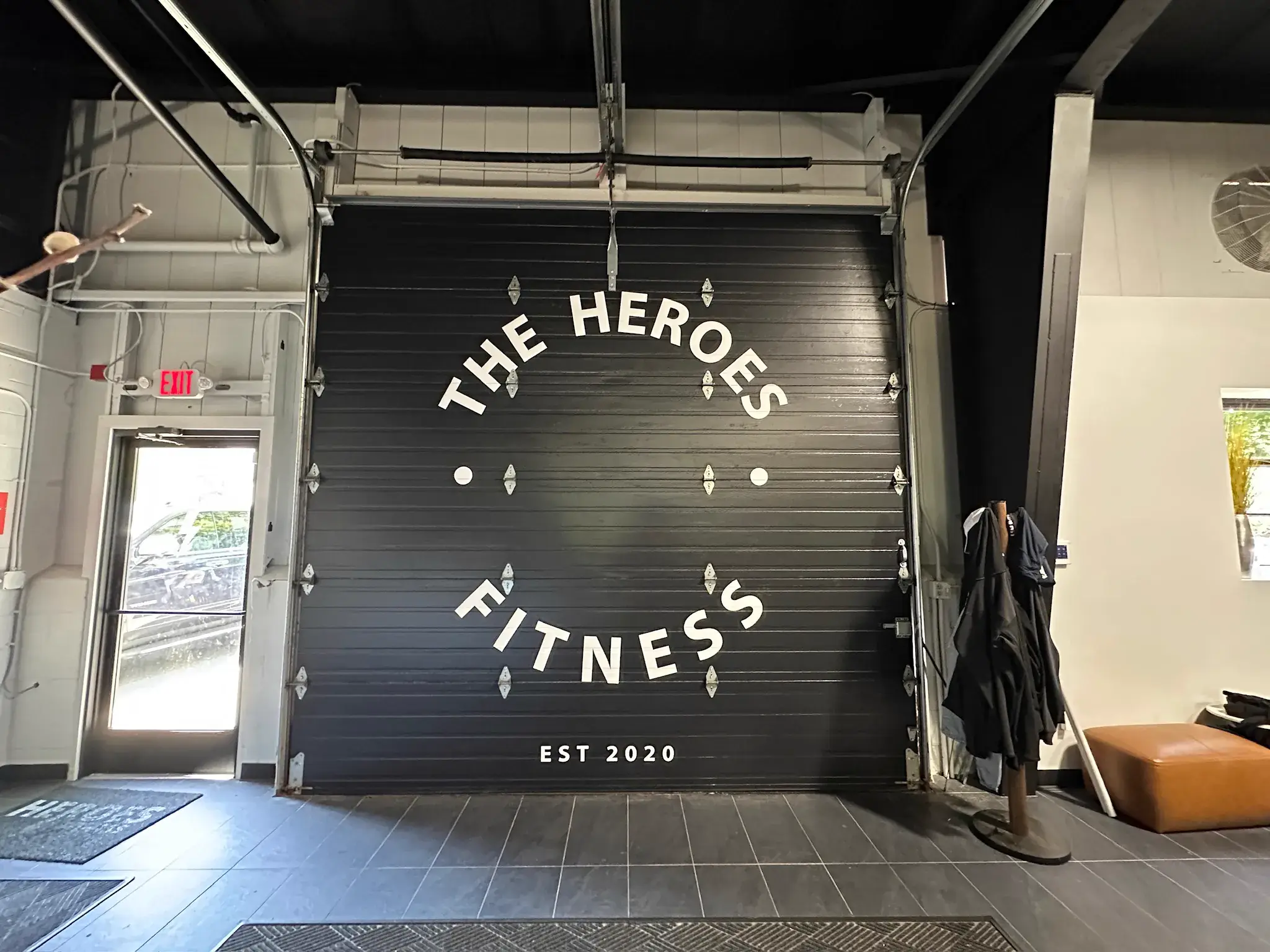 White dimensional letters arranged in a circle on a black roll-up garage door