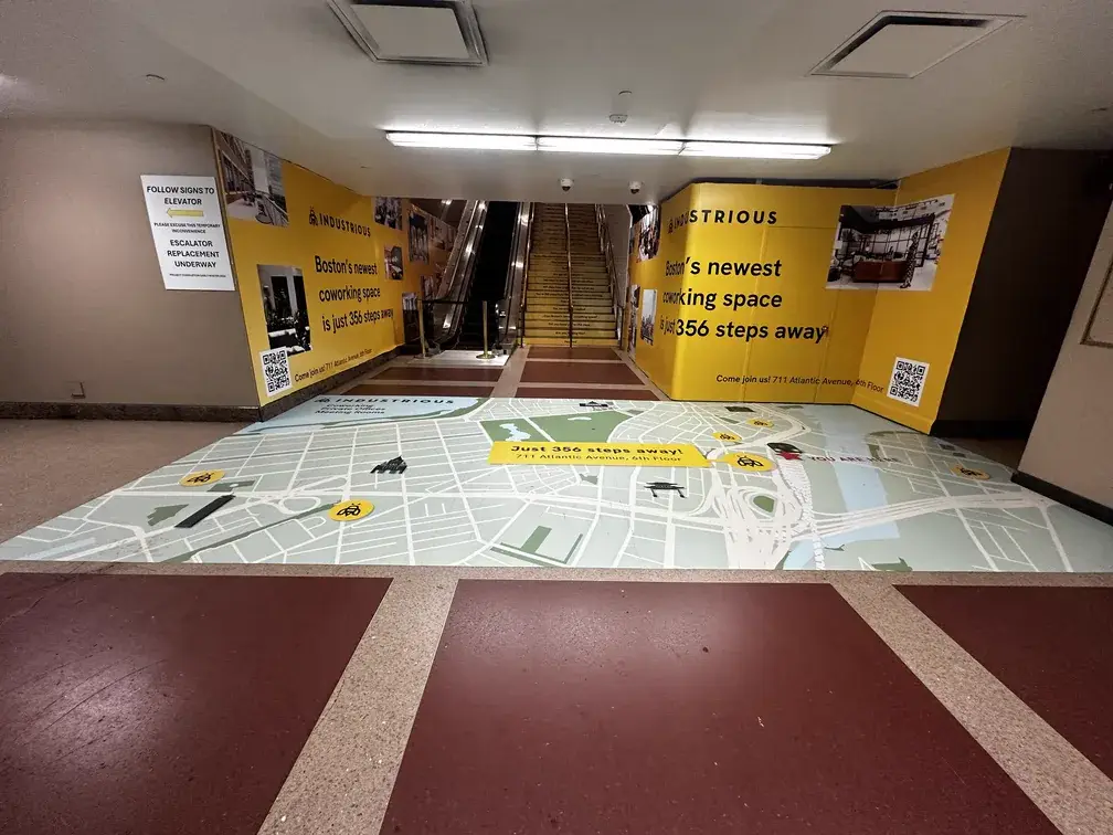 Wide view of Industrious escalator and floor wayfinding graphics