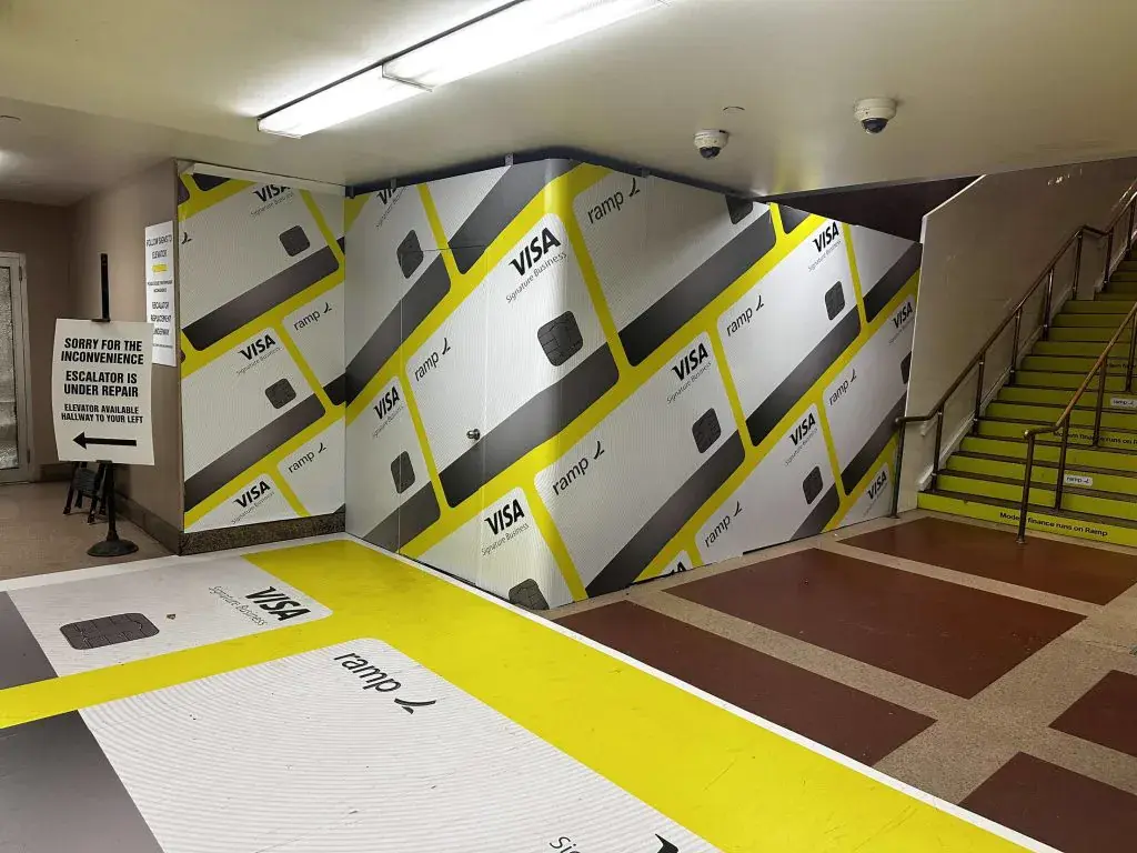 Ramp and Visa branded stair, wall and floor wrap in a transit station