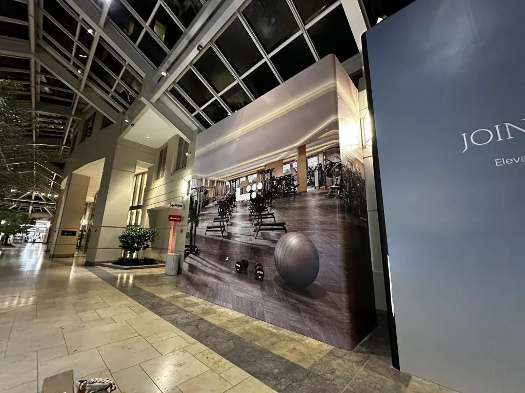 Fitness club construction hoarding in an atrium lobby