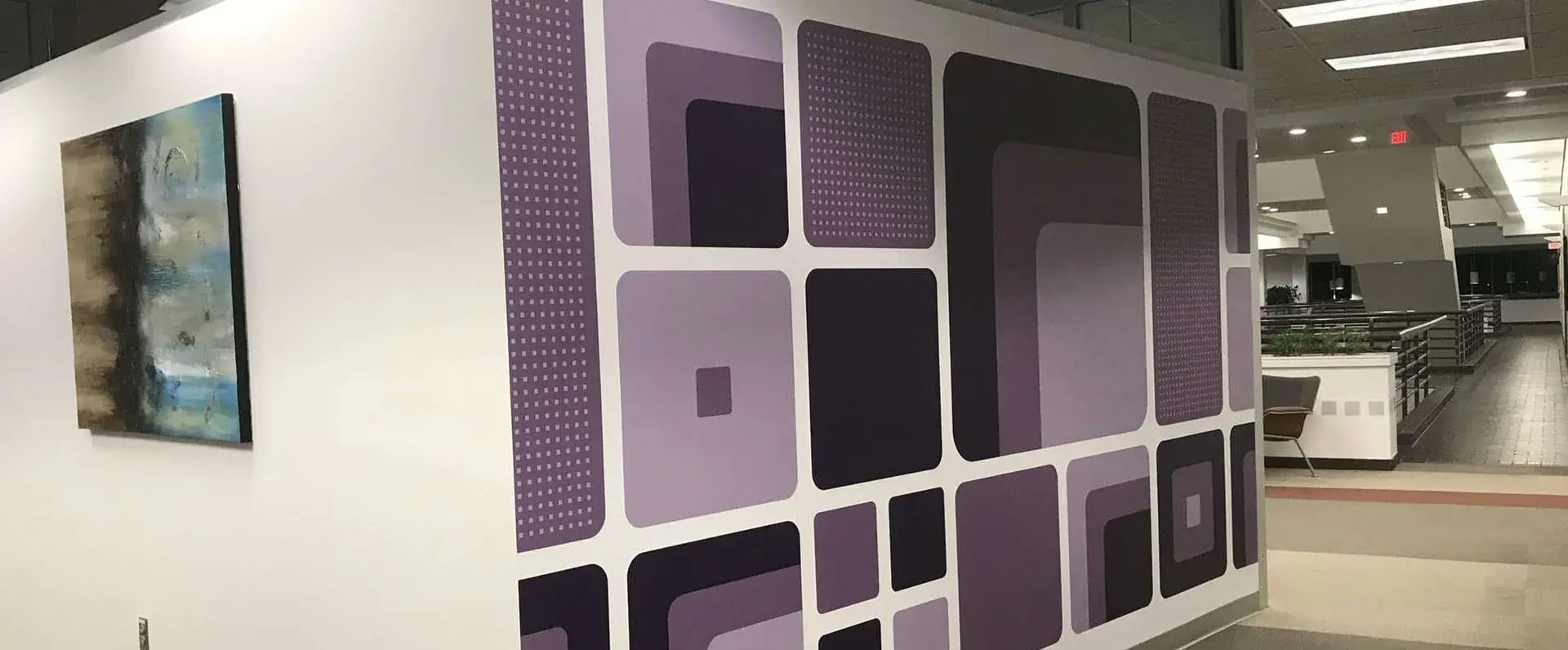 Geometric purple wall mural in an office corridor